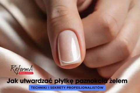 Dłoń z paznokciem pomalowanym jasnym lakierem z brokatem, na tle satynowej tkaniny.