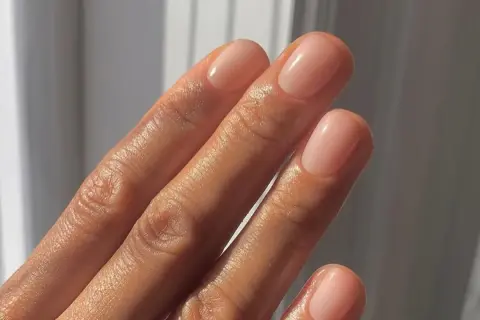 Dłoń z paznokciami po japońskim manicure, w naturalnym, różowym odcieniu.