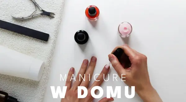 Dłoń malująca paznokcie lakierem, obok buteleczki z lakierami i akcesoria do manicure.