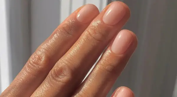 Dłoń z paznokciami po japońskim manicure, w naturalnym, różowym odcieniu.